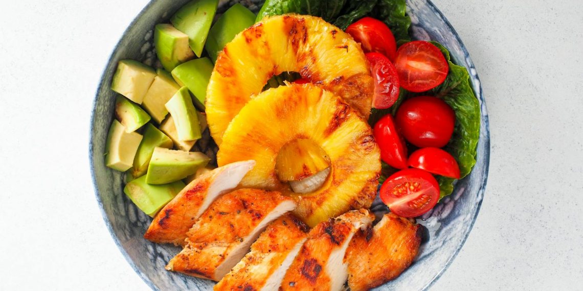 Bowl of Sliced Fruits, Checken, and Chopped Avocado