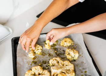 Hands of Persons Holding Baked Cauliflower